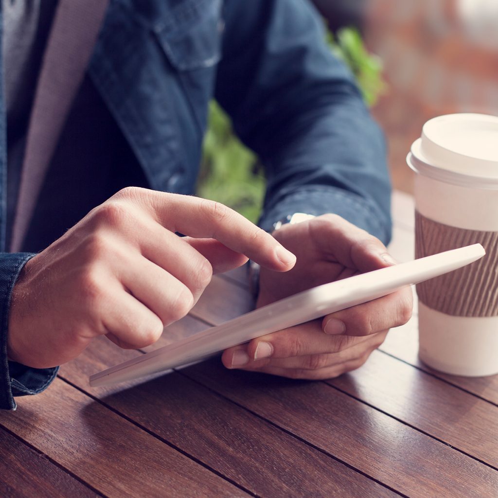 Using-a-tablet-on-table-with-coffee